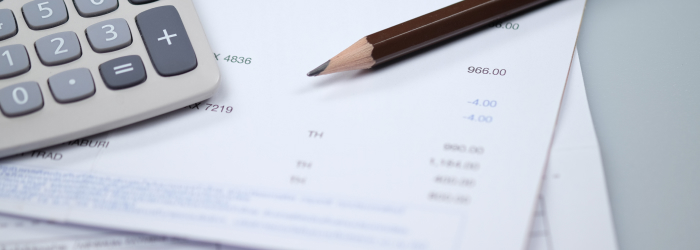 Household bills and calculator used to review energy costs and compare tariffs