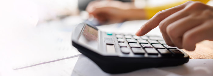 Person using a calculator to estimate energy savings and household costs