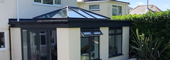 Modern home with black-framed glass conservatory roof by SupaLite, combining energy efficiency and contemporary design.