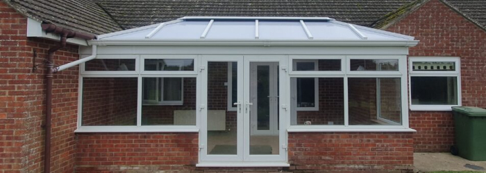 Brick home with a white-framed SupaLite tiled conservatory roof, transforming a traditional conservatory into an energy-efficient living space.