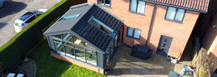 Modern home with SupaLite tiled conservatory roof and skylights, creating a bright and energy-efficient extension with a sleek contemporary design.