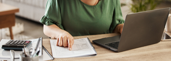 Homeowner planning an affordable house extension budget using a laptop and calculator