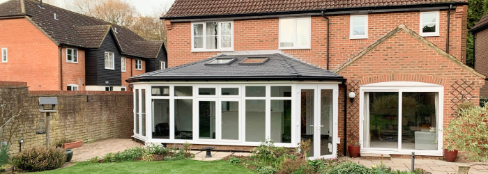 Modern conservatory with a tiled replacement roof attached to a detached family home