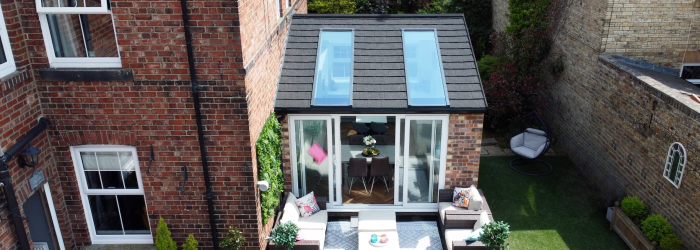 Small modern lean-to conservatory extension with tiled roof and roof windows